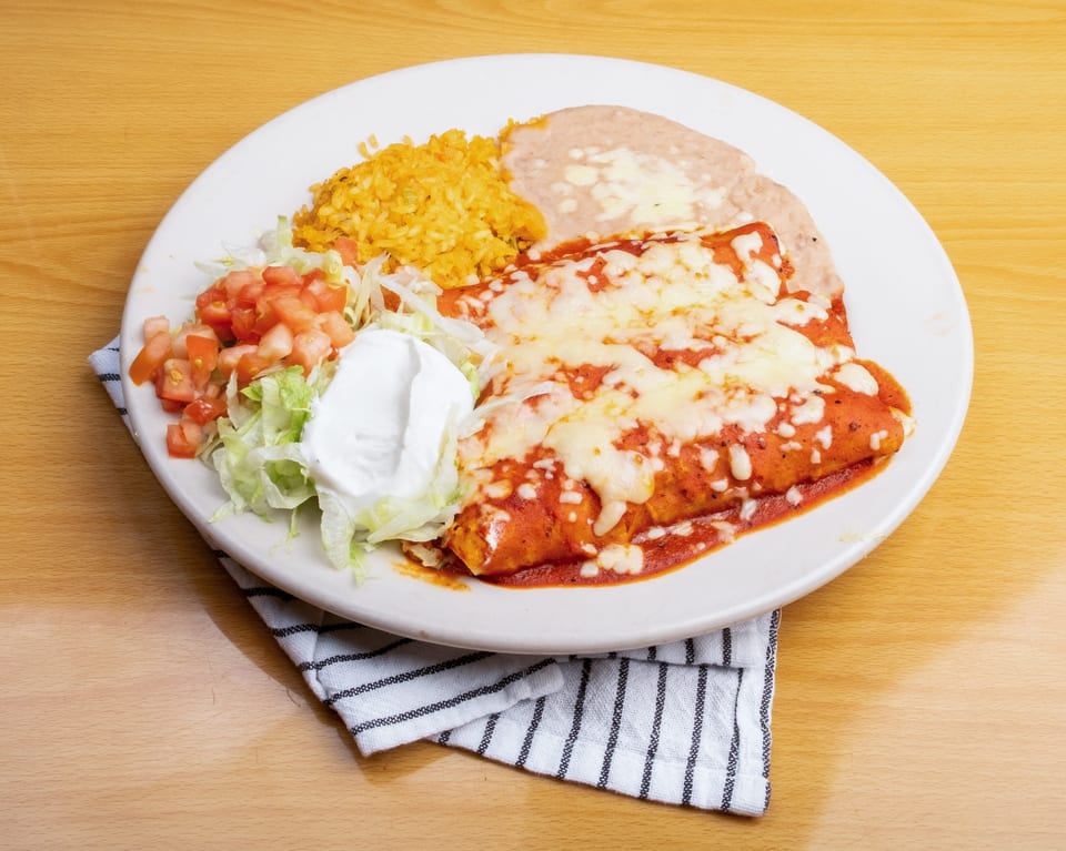 Two cheese enchiladas covered in red sauce and melted cheese, with rice, refried beans, and salad.